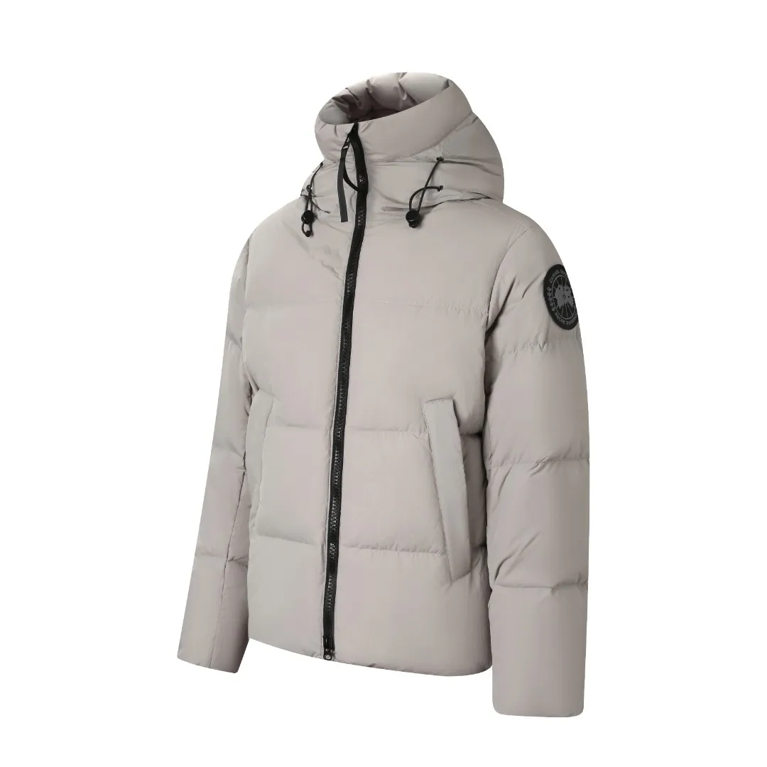 P980 Canada Goose hooded down jacket Fabric selection: Weaved with 400T high-count yarn. After special water-repellent treatment, the surface forms a lotus leaf effect - raindrops will slide down in beads, and snow particles will fall off when touched. The tear resistance reaches 200N (approximately 20kg load-bearing), the light gray matte texture breaks the stereotype of "outdoor clothing = hardcore", and the soft luster presents a high-end matte effect under urban neon lights, seamlessly switching scenes from ski resorts to CBD office buildings.  Process 1: Use polyester woven ribbons as the base, and use high-precision computer embroidery to decorate the brand letters on the ribbons. The edges of the pattern are clear, the stitches are fine and even, and multiple layers of embroidery threads are stacked to enhance the three-dimensional effect.  Process 2: Precision thread reinforcement to prevent velvet drilling and ensure that the fluffy and resilient elasticity lasts as new.  Details: The embedded cuffs are three-dimensionally woven to form a "wavy" elastic structure, forming natural folds when fitting the wrist, increasing the contact area with the skin, thus improving the windproof effect. At the same time, micro-velvet treatment is added to the inside of the cuffs, which feels like a second layer of skin and avoids friction on the skin from metal zippers or hard fabrics.  90 national standard high-quality white duck down: selected high-loft down, weighing 240g, light and warm, with excellent temperature locking performance and good resilience.  Accessories: 1:1 customized armband, 1:1 customized zipper pendant, 1:1 customized elastic buckle, etc. SIZE: S M L XL